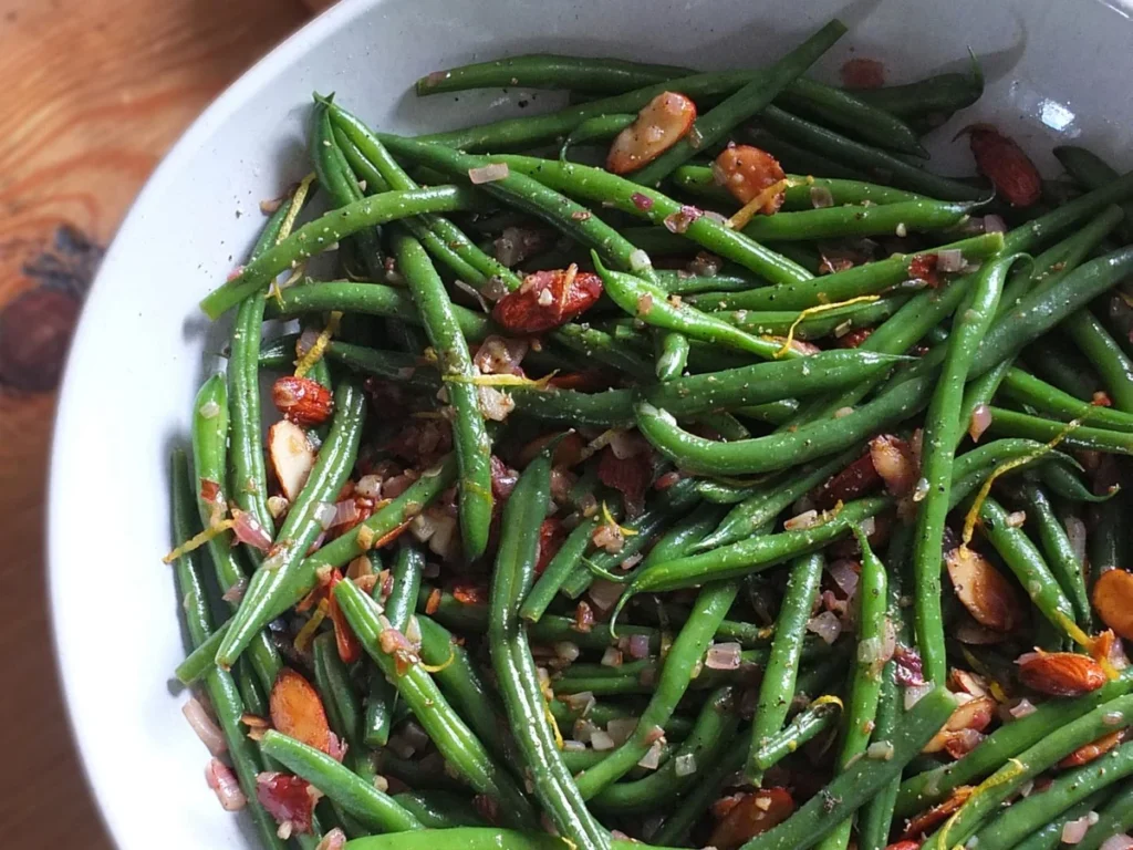 Green beans almondine plated with toasted almonds and lemon