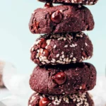 Stack of fudgy chocolate tahini cookies with molten chips