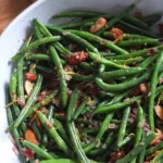 Green beans almondine plated with toasted almonds and lemon