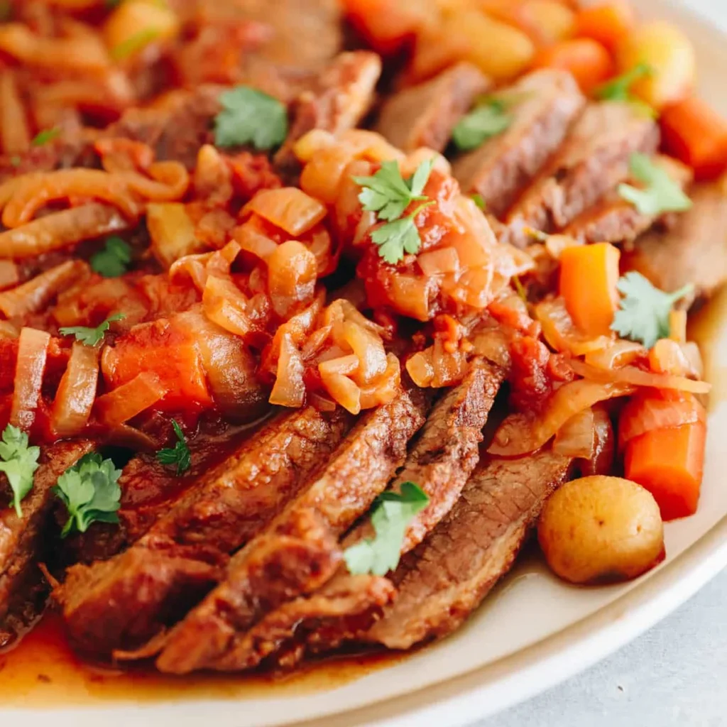 Sliced oven-braised brisket in rich sauce with onions and carrots