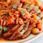 Sliced oven-braised brisket in rich sauce with onions and carrots