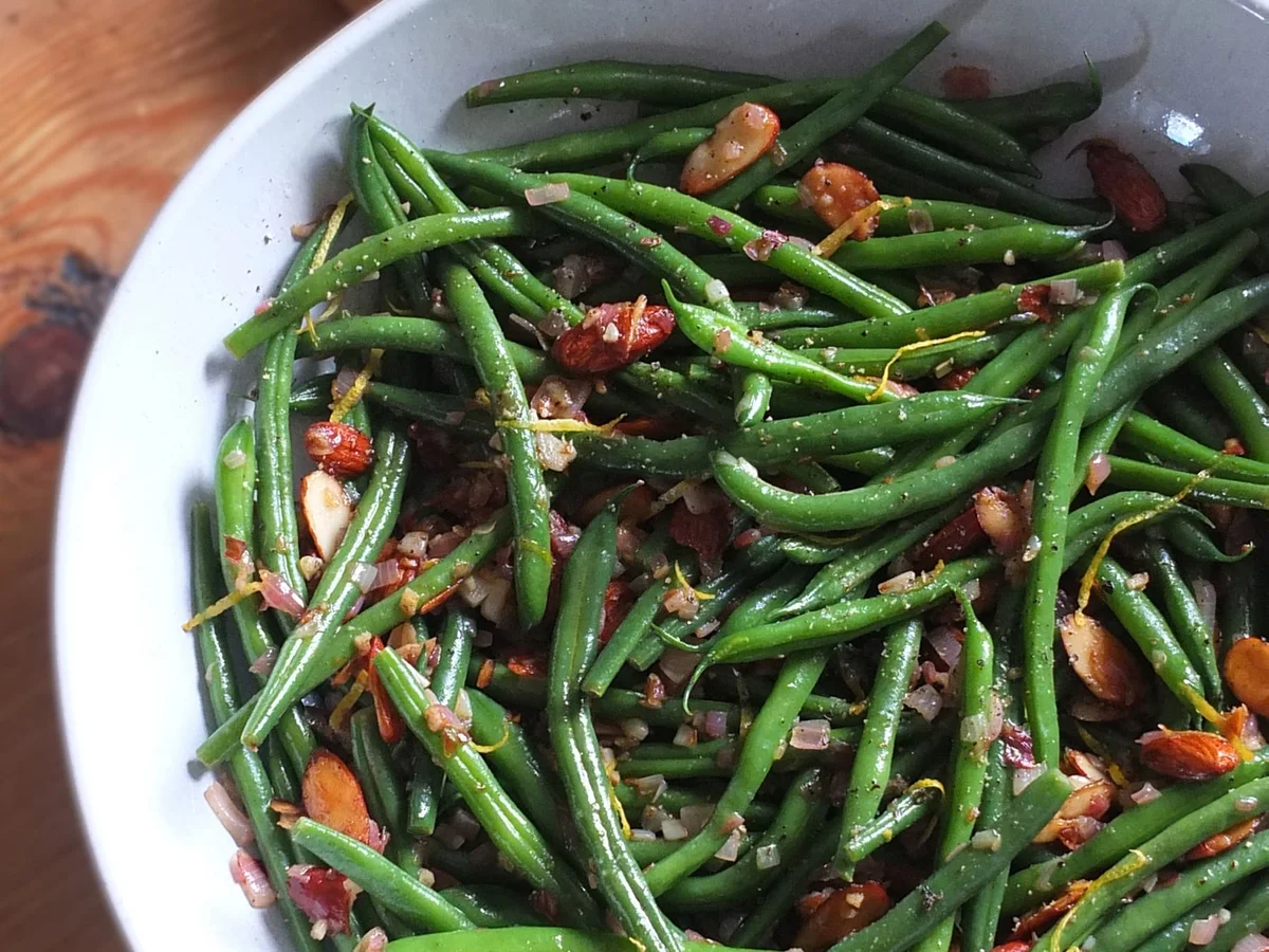 Green beans almondine plated with toasted almonds and lemon
