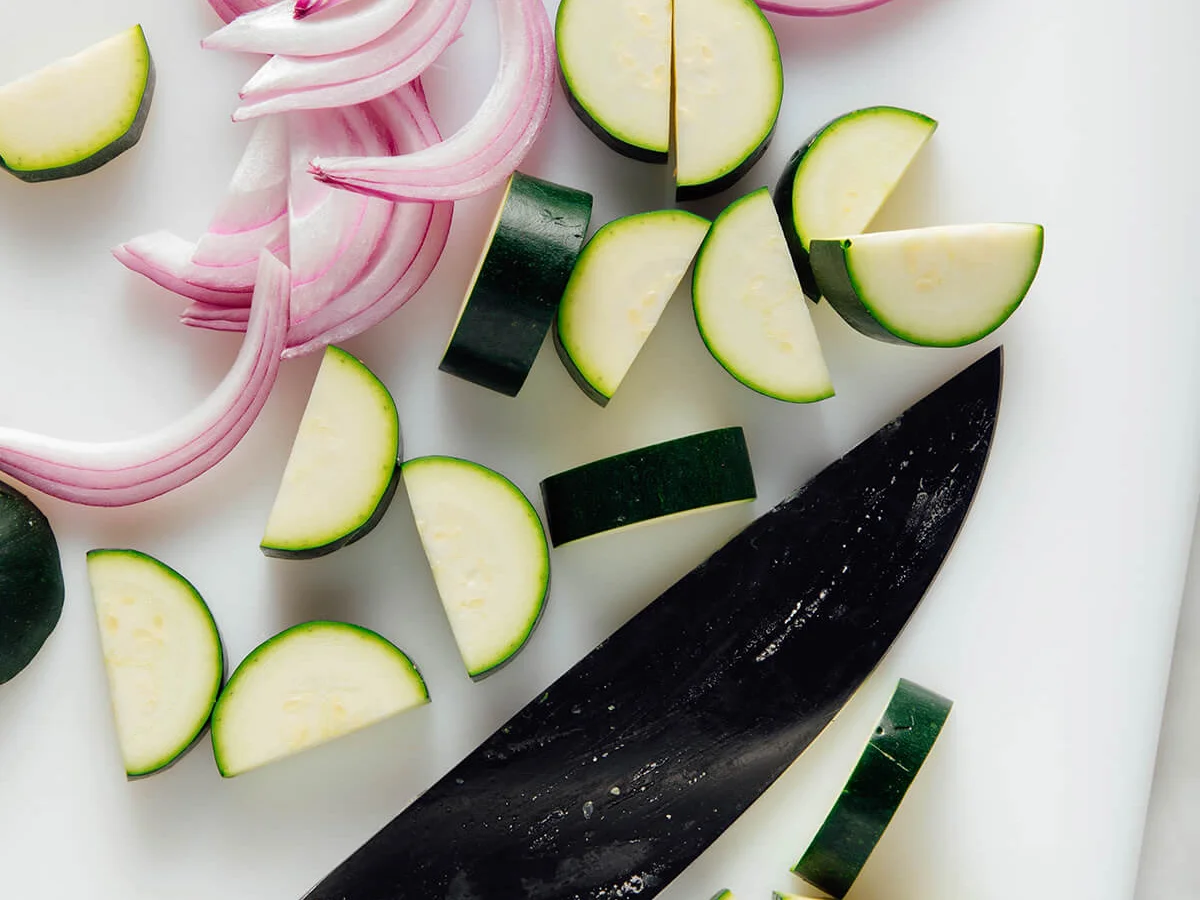 Zucchini and red onion sliced on a cutting board
