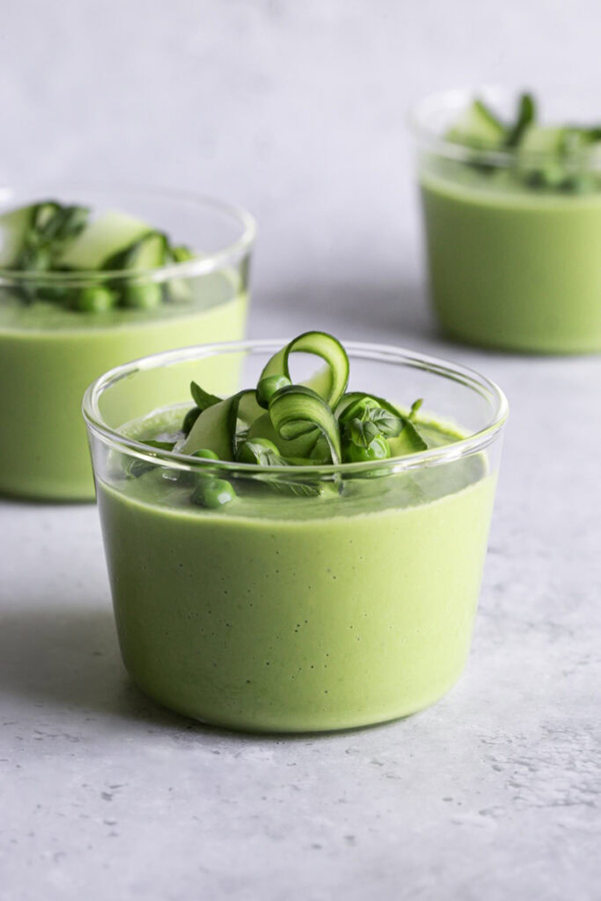 Close-up of green gazpacho served in glass with cucumber garnish