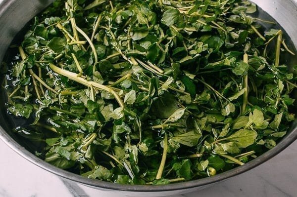 Pan-fried watercress stir-frayed with garlic and oil in a black wok