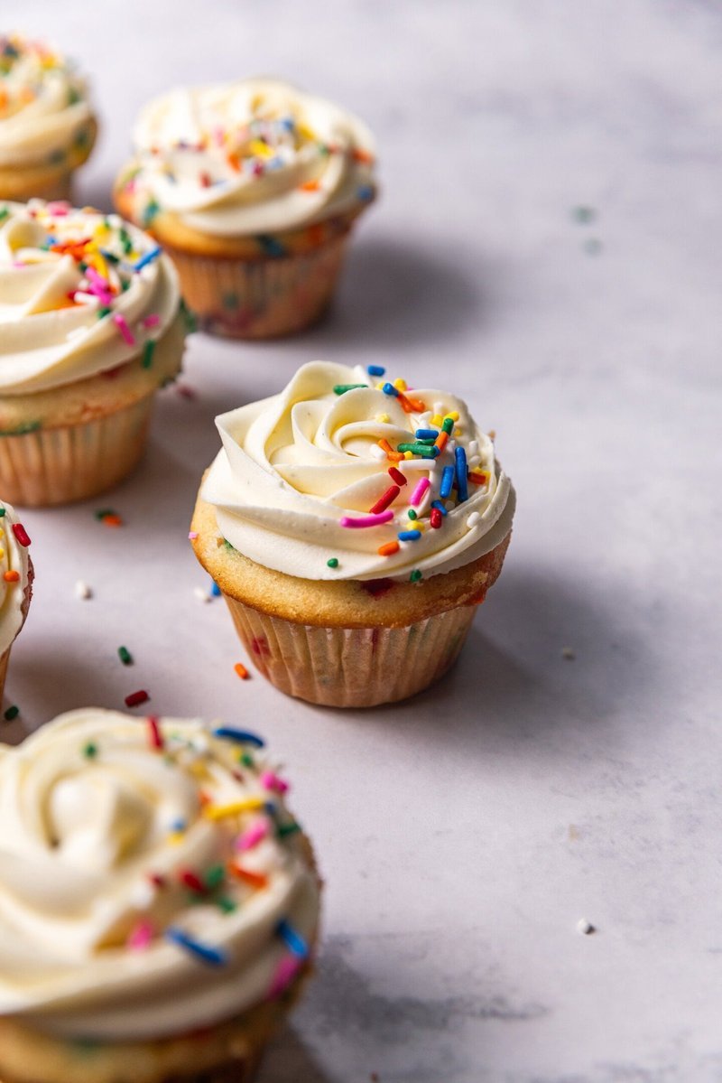 Cut funfetti cupcake showing sprinkle-filled interior crumb