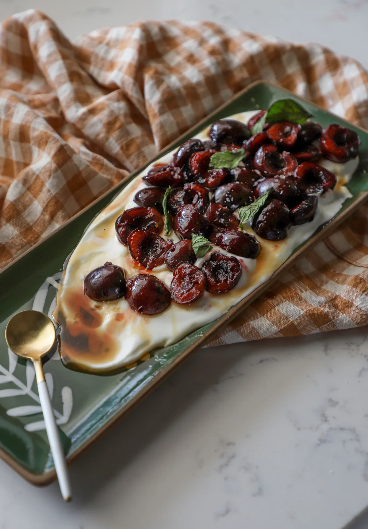 Grilled cherry and whipped goat cheese appetizer on green platter