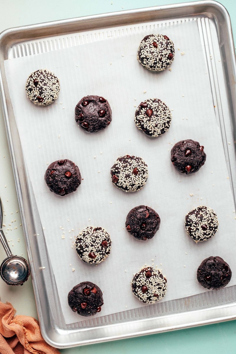 Chocolate cookie dough balls on parchment-lined baking sheet