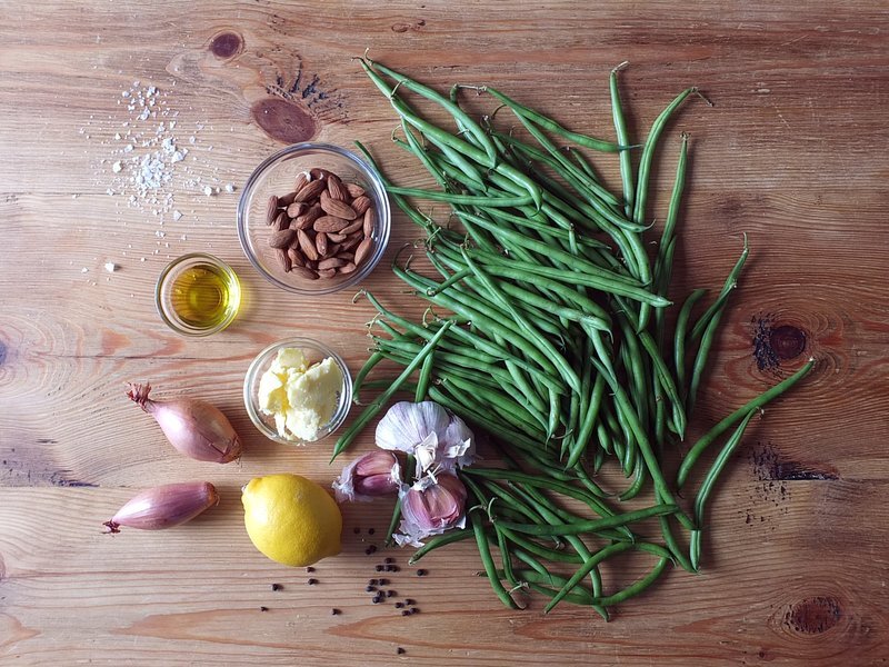 Raw green beans, almonds, lemon and shallots laid out