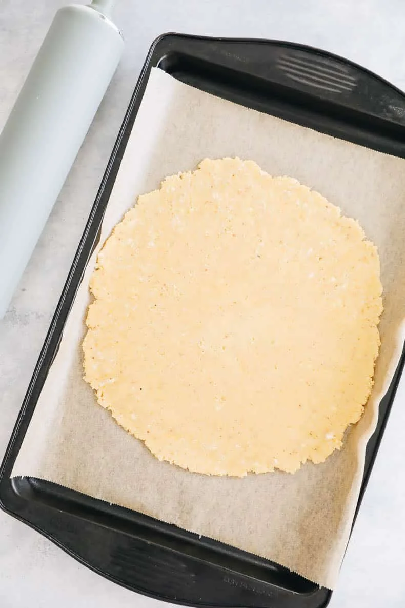 Rolled-out galette crust on parchment paper in a baking tray