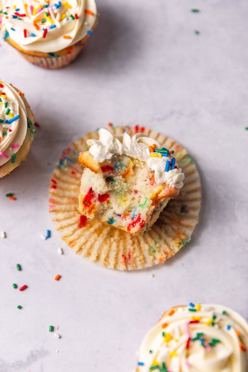 Bite taken from a funfetti cupcake revealing moist interior