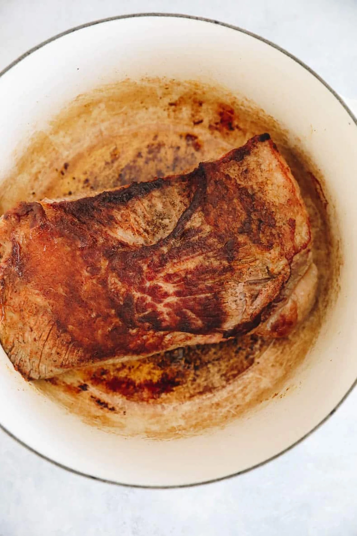 Garlic cloves tucked into seared brisket cuts