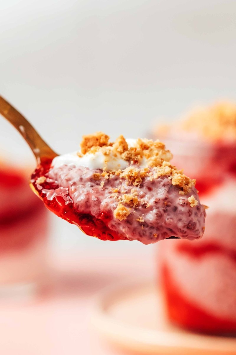 Spoonful of layered strawberry chia pudding showing creamy texture