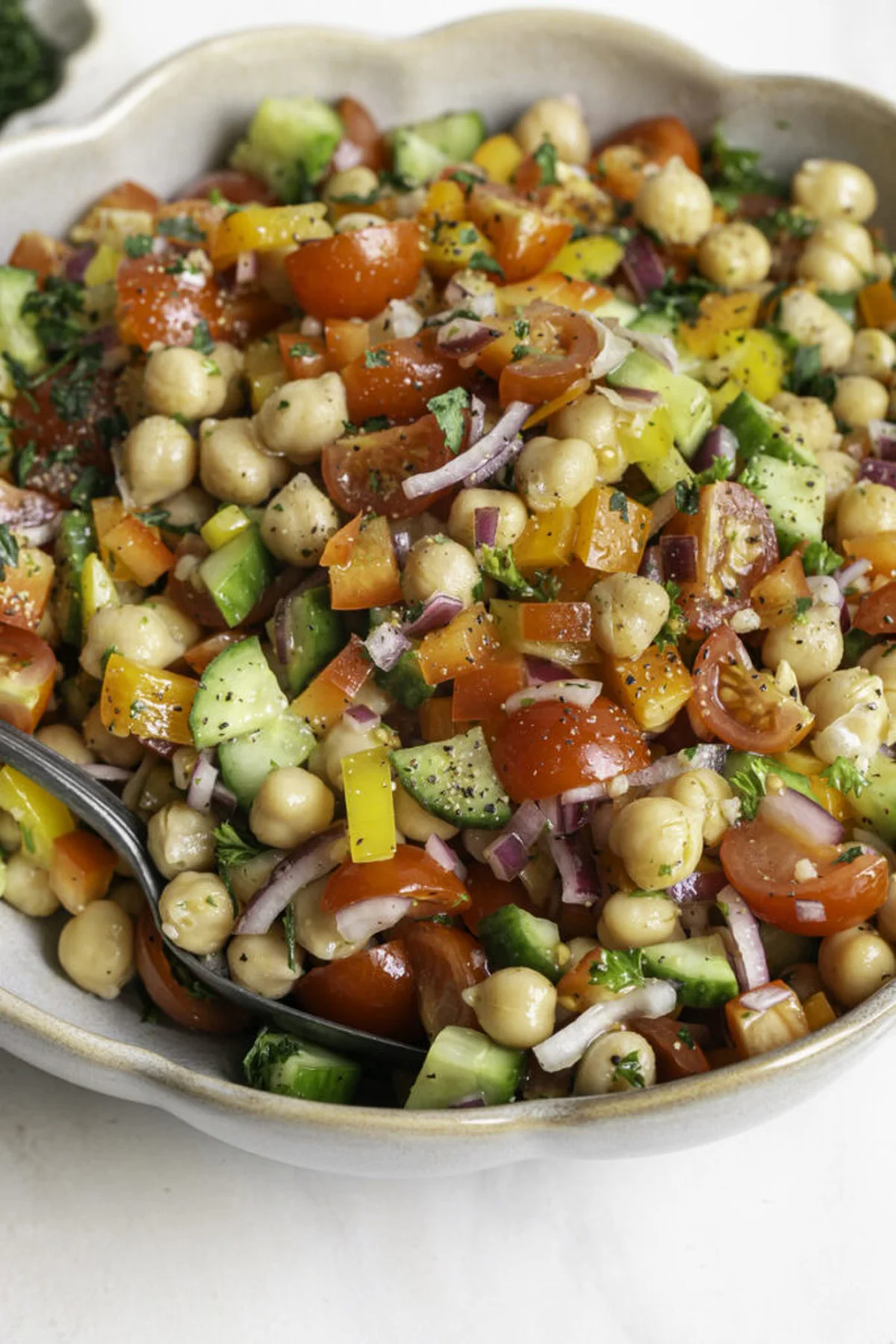 Hand mixing chickpea salad with lemon dressing