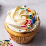 Overhead view of frosted funfetti cupcakes with scattered sprinkles