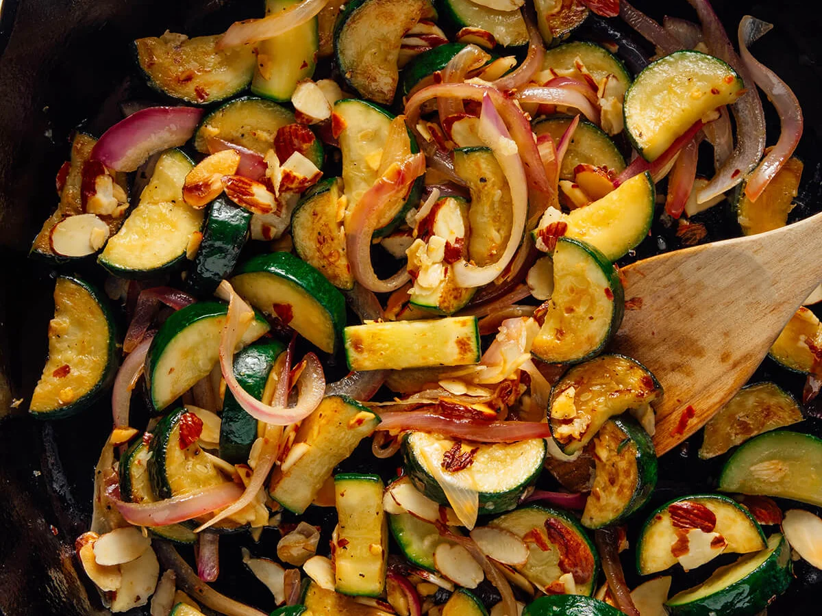 Sautéed zucchini with toasted almonds in a cast iron pan