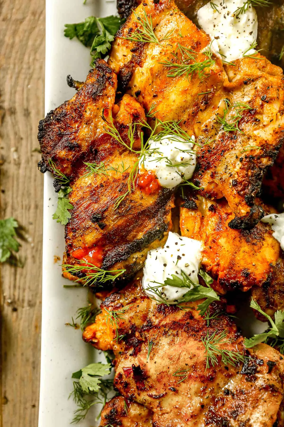 Harissa chicken thighs with charred edges on a serving platter