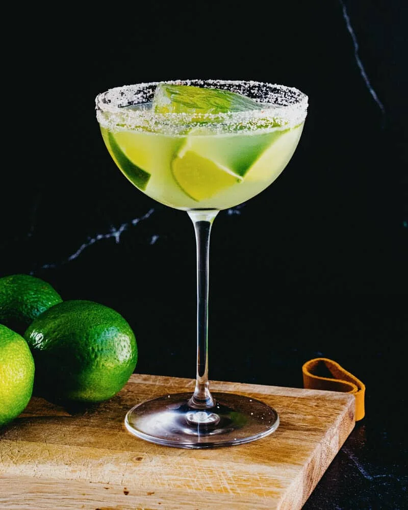 Texas margarita in a salt-rimmed coupe glass with lime wedges