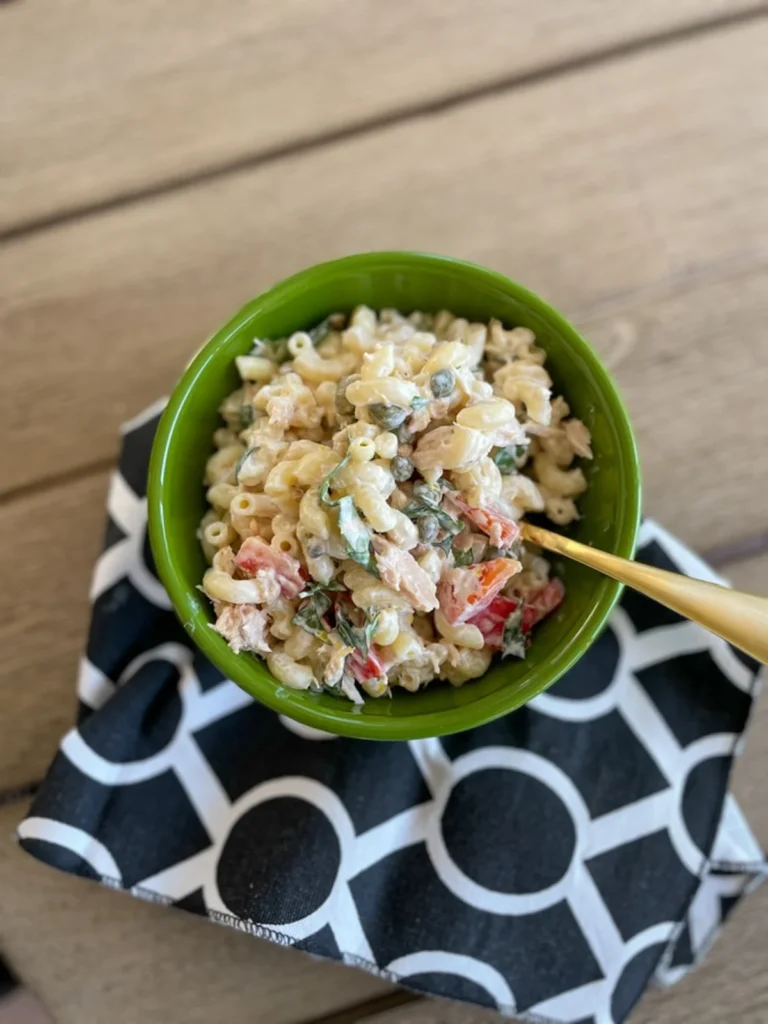 Creamy tuna pasta salad in a green bowl with a spoon