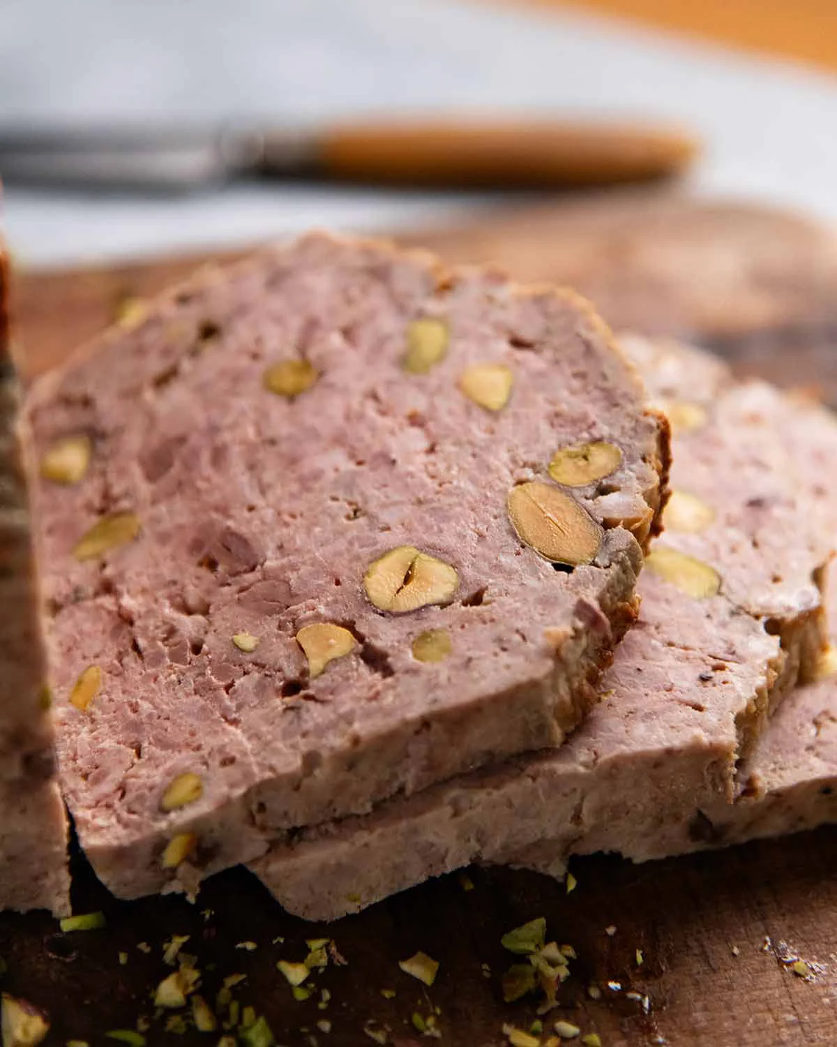 Sliced country terrine with pistachios on a wooden board