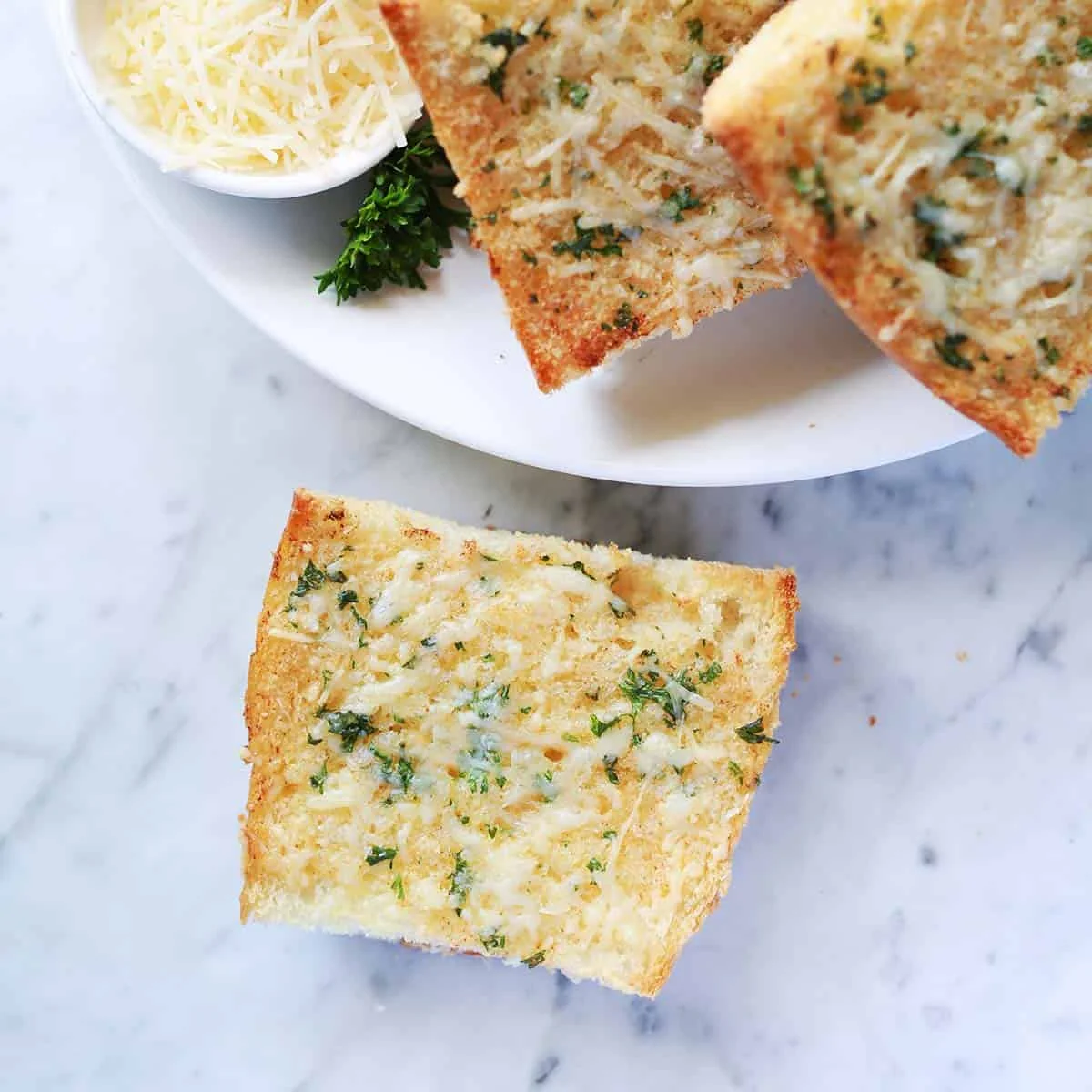 Golden garlic toast slices topped with melted parmesan and parsley