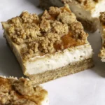 Sliced vegan cinnamon cookie cheesecake crumb bars with golden crumble