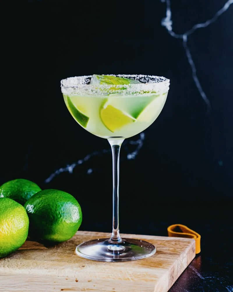 Texas margarita with fresh limes on a wooden board