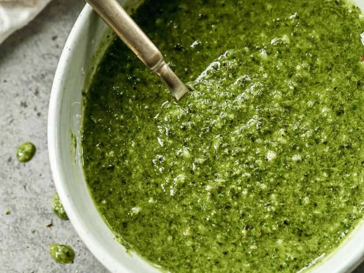 Bright green fresh basil pesto in a glass jar