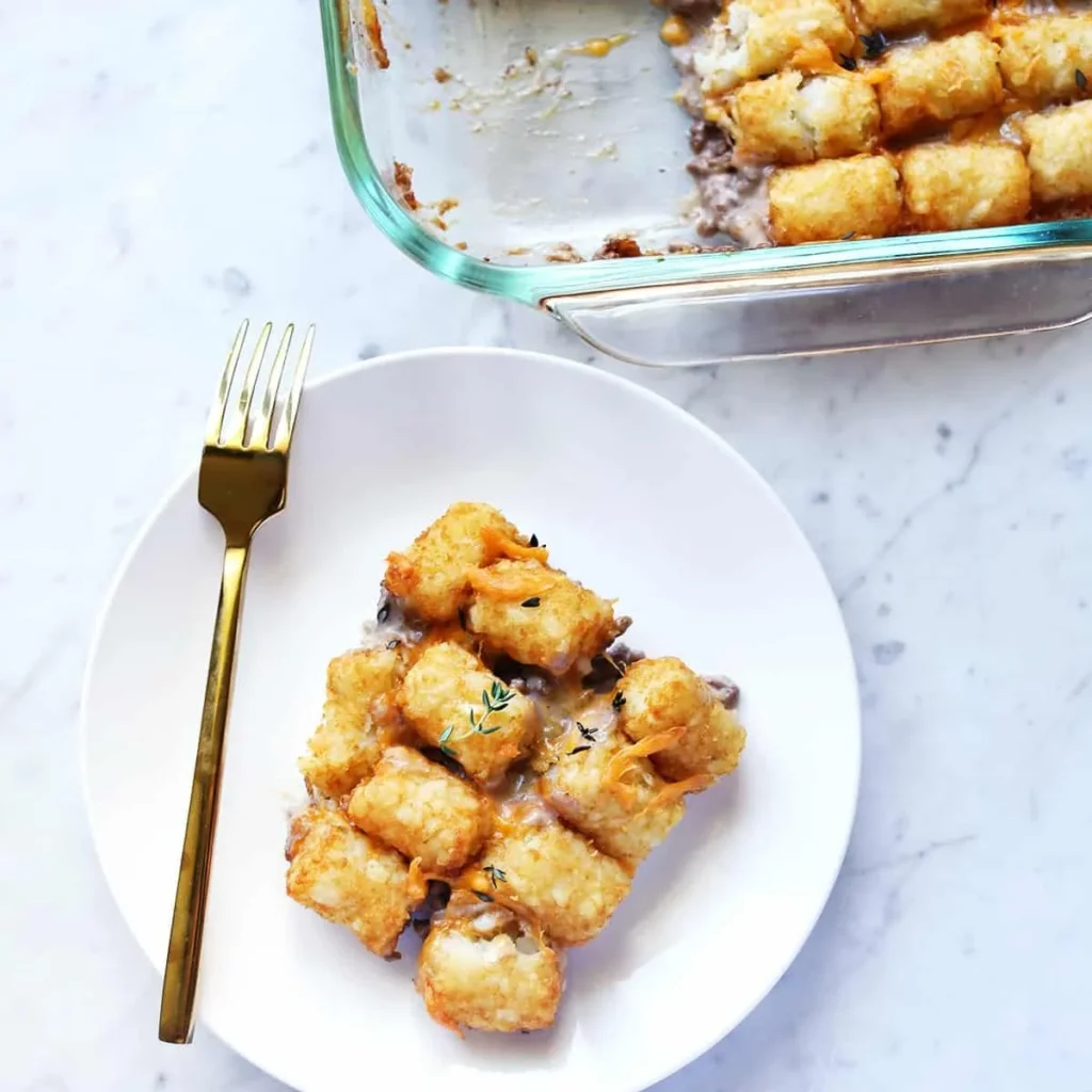 Close-up of crispy tater tots bubbling on top of the casserole