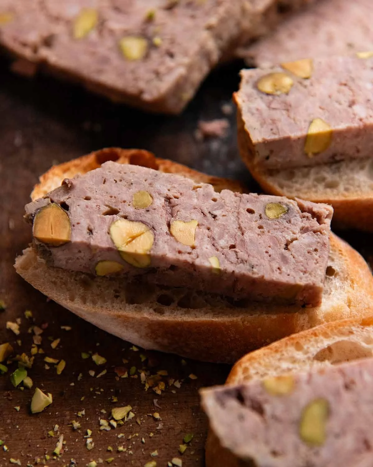 Thick terrine slice on crusty bread with pickled garnish