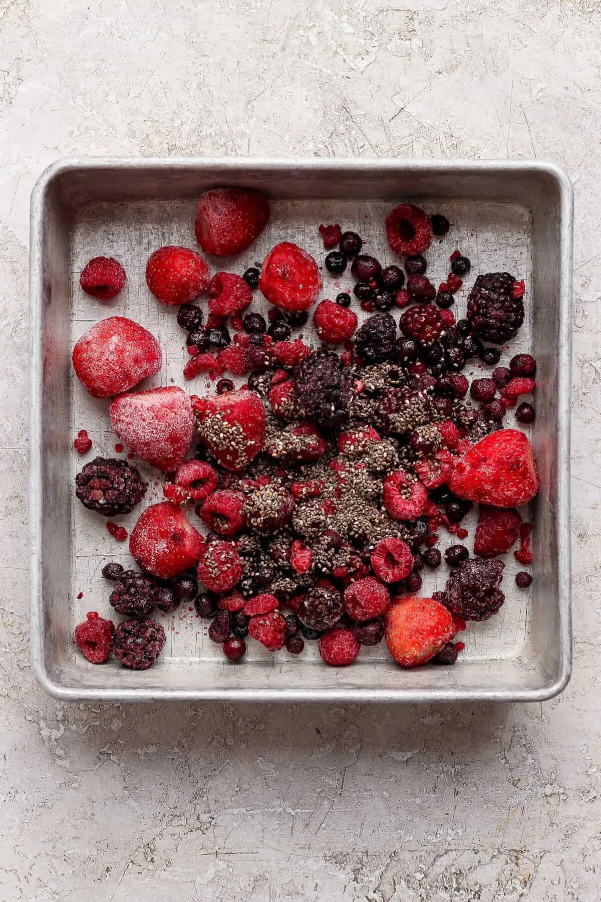 Frozen berries and chia seeds spread in a baking dish