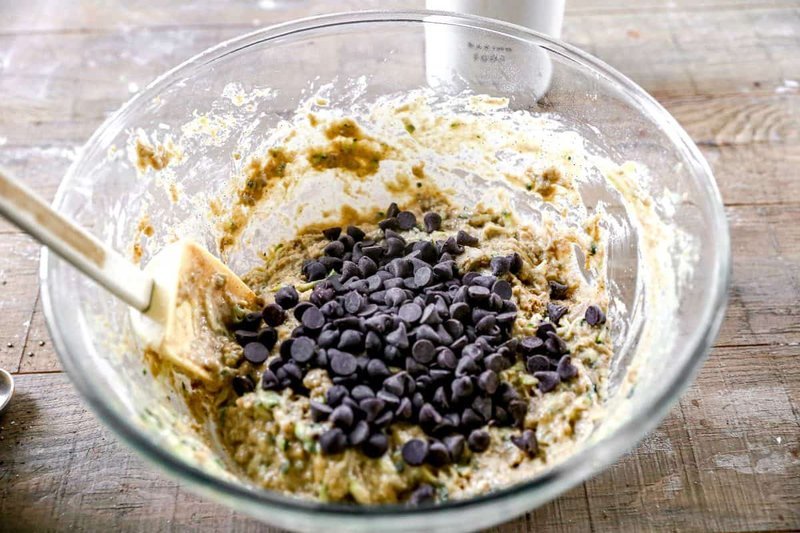 Chocolate chips folded into thick zucchini bread batter