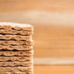 Stack of crisp whole-grain graham-style crackers on a wooden table