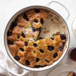 Sliced blackberry skillet pancake in cast iron with syrup
