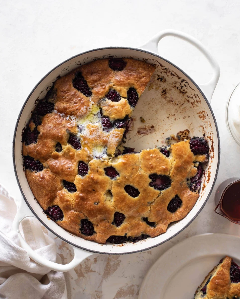 Sliced blackberry skillet pancake in cast iron with syrup
