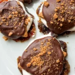 Top-down view of smashed date s'mores with chocolate drizzle