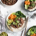 Slow cooker Korean-style beef bowls with rice and fresh vegetable sides