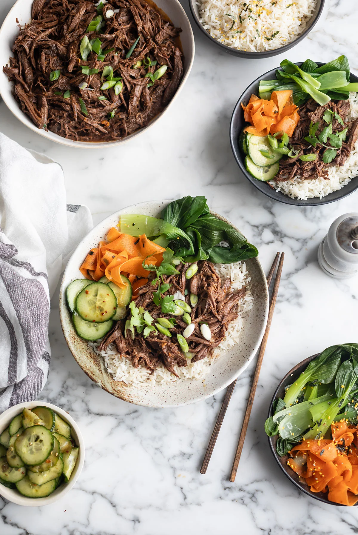 Slow cooker Korean-style beef bowls with rice and fresh vegetable sides