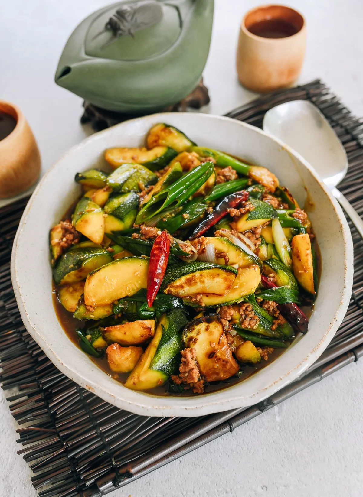 Zucchini garlic sauce stir-fry in a ceramic bowl with chopsticks