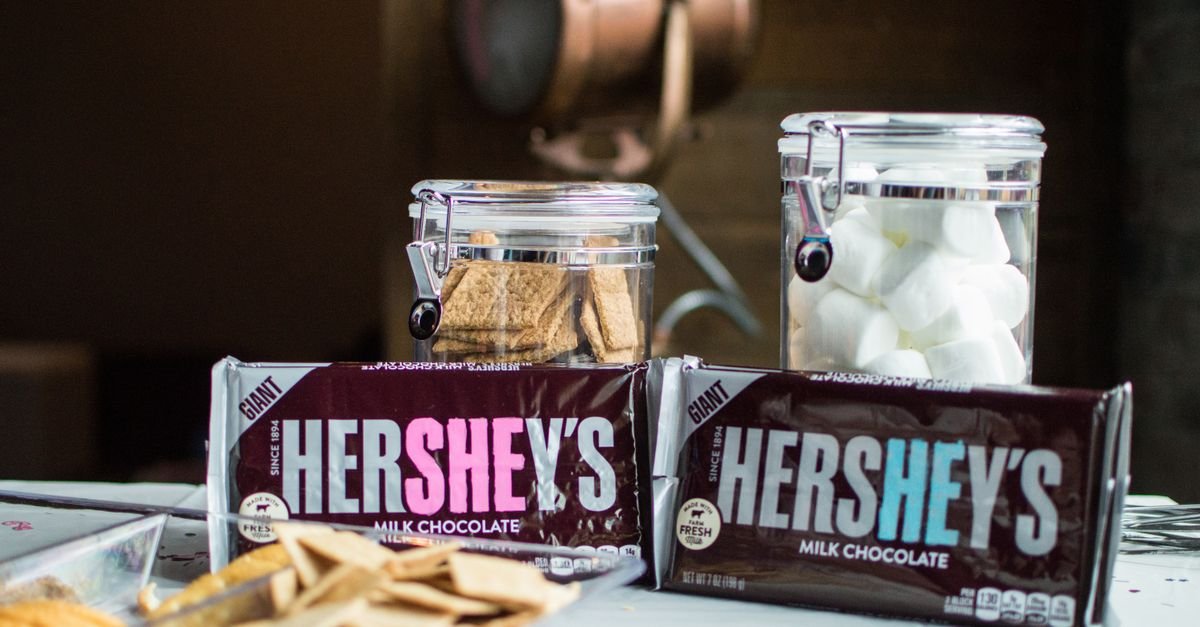 Graham crackers in jars beside chocolate and marshmallows for s'mores