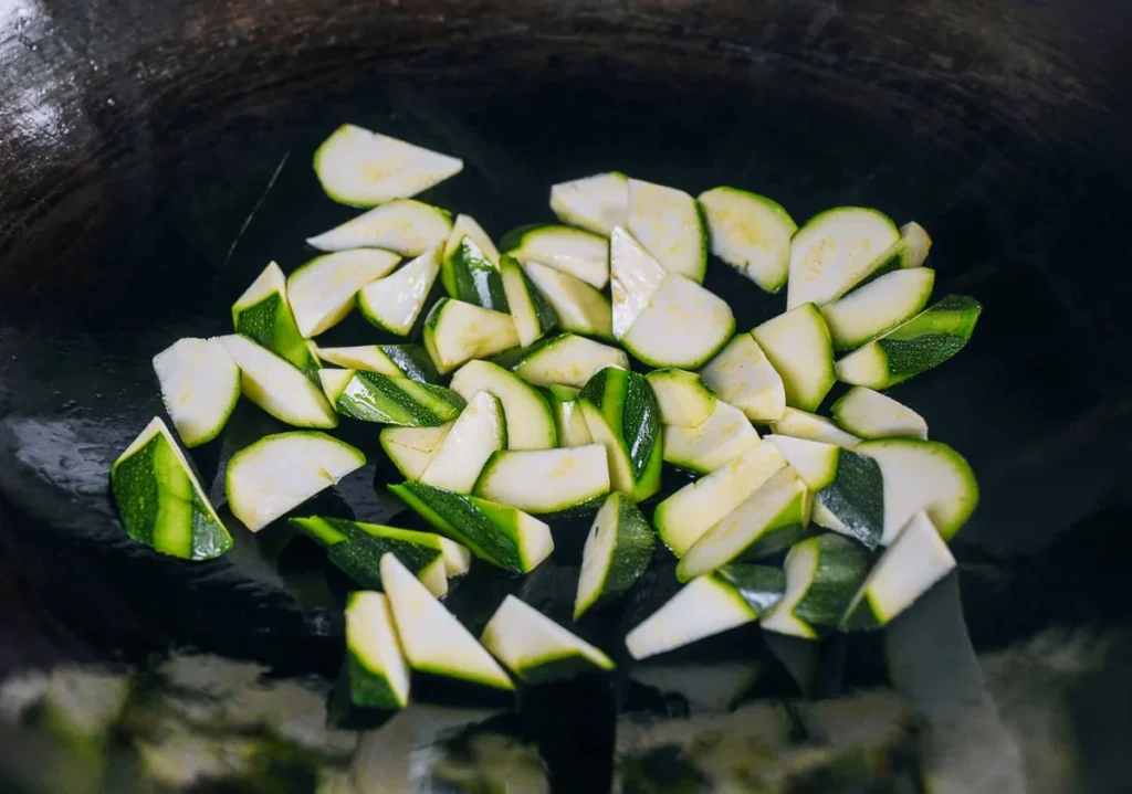 Zucchini chunks browning in a hot wok