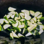 Zucchini chunks browning in a hot wok