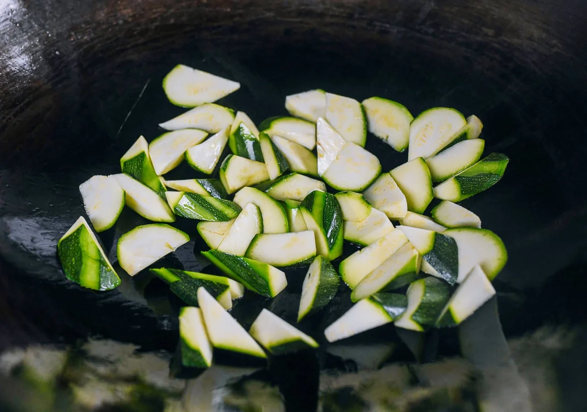 Zucchini chunks browning in a hot wok