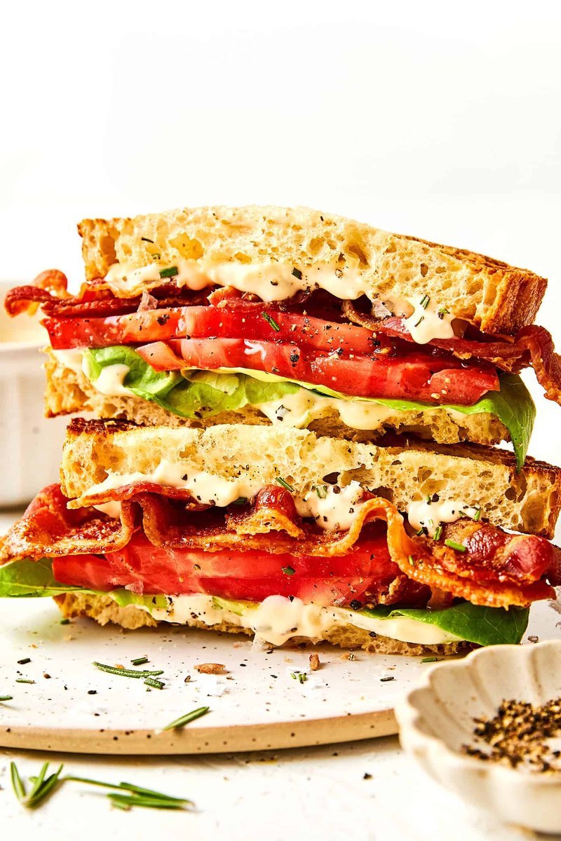 Stacked BLT sandwich halves with rosemary mayo and peppercorns