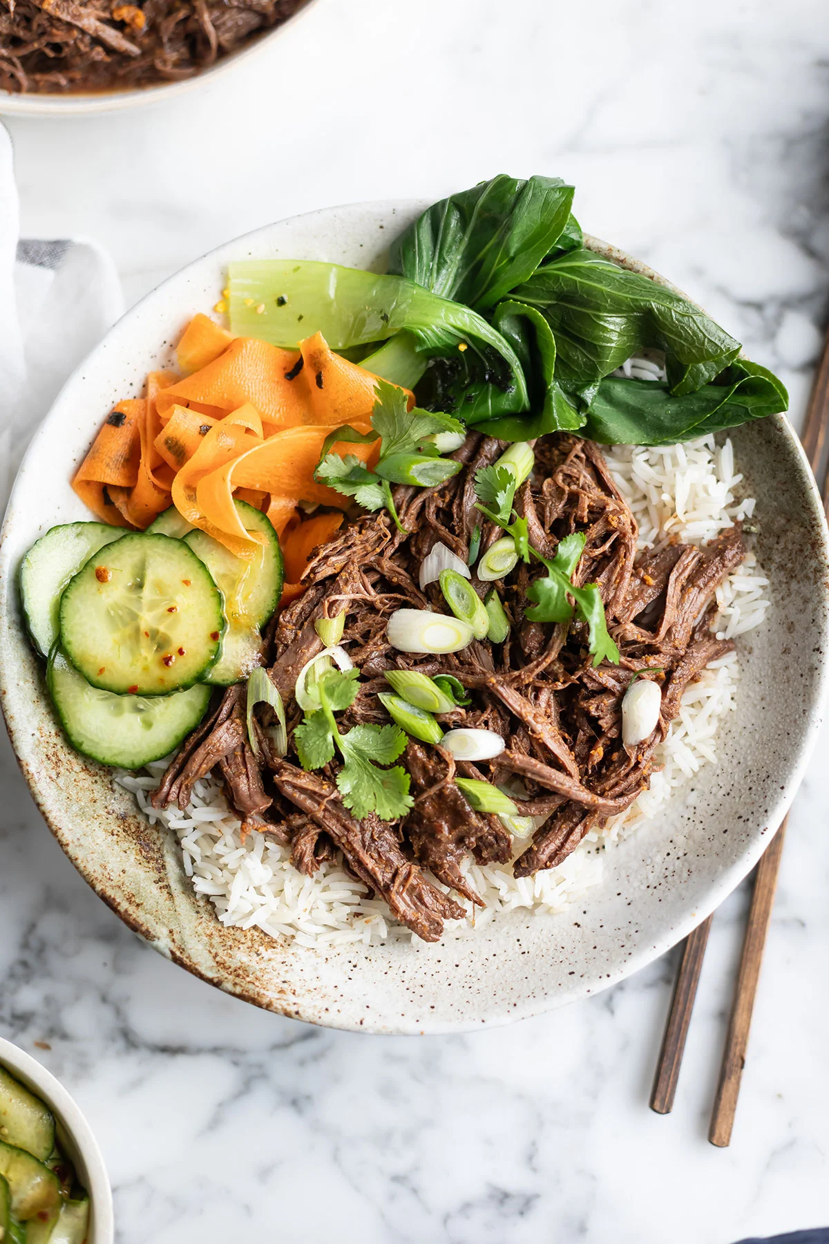 Plated Korean-style beef bowl over rice with spring onions